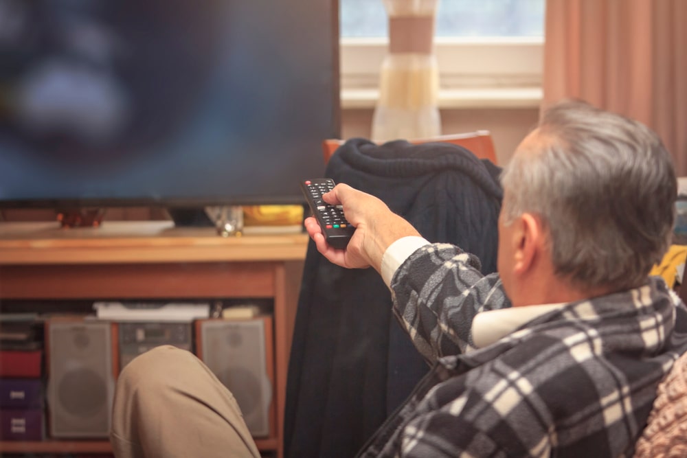 Mann stellt Fernseher lauter