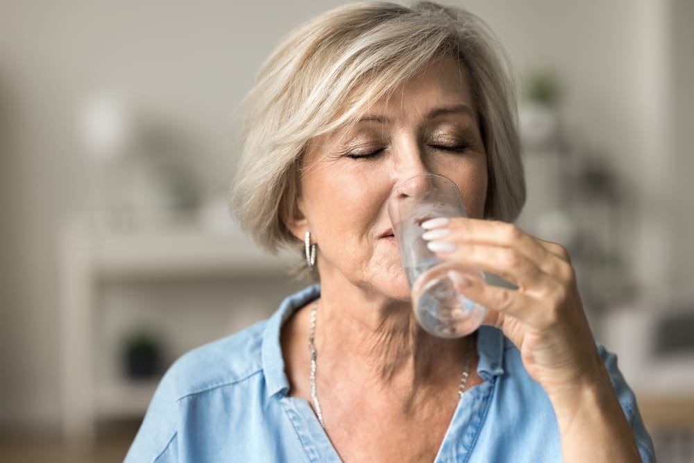 Seniorin trinkt Wasser